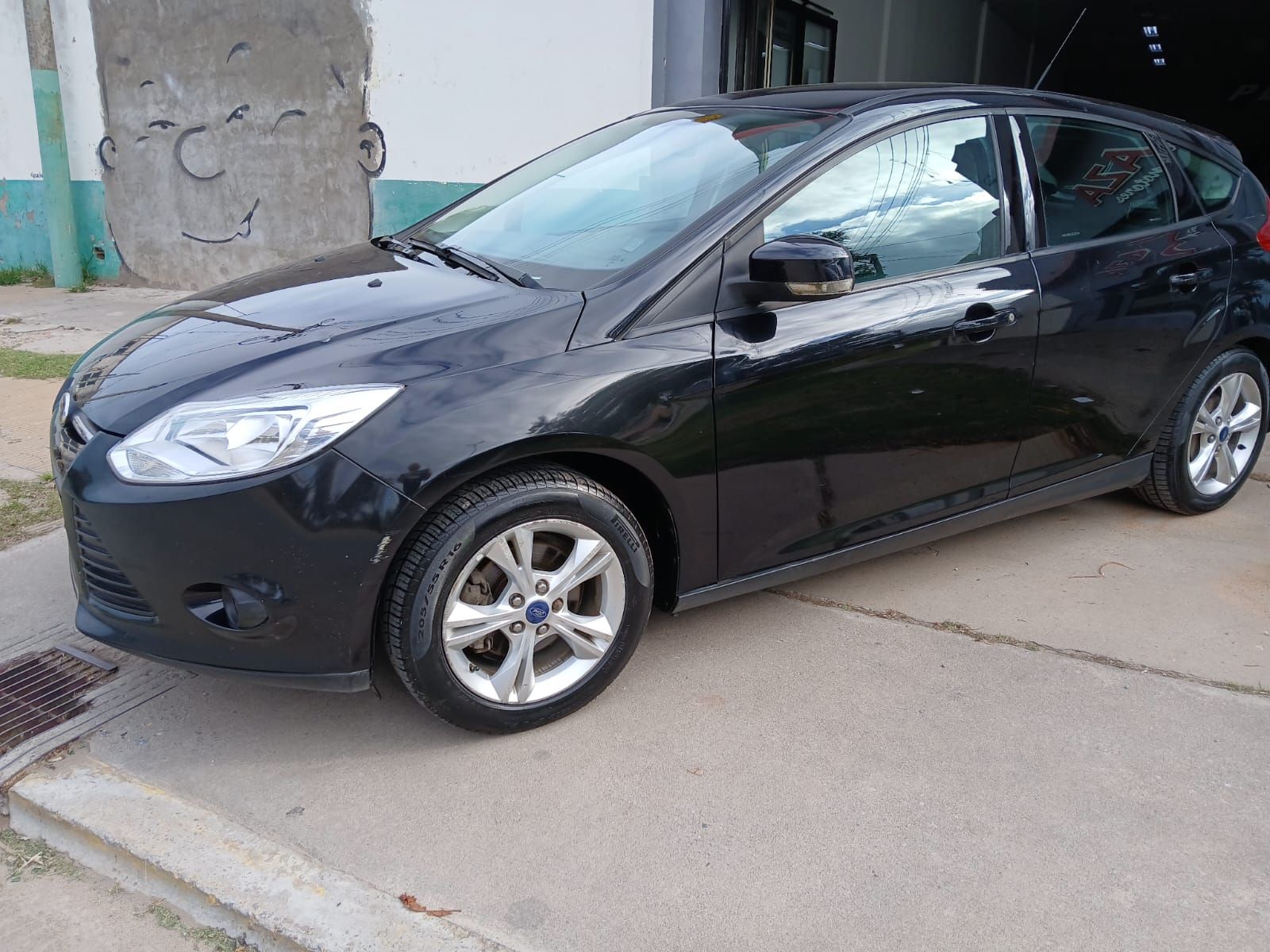 Ford Focus hatchback negro estacionado sobre concreto.