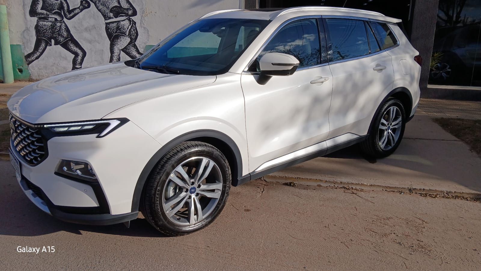 SUV Ford Territory color blanco estacionado sobre asfalto, vista frontal izquierda.