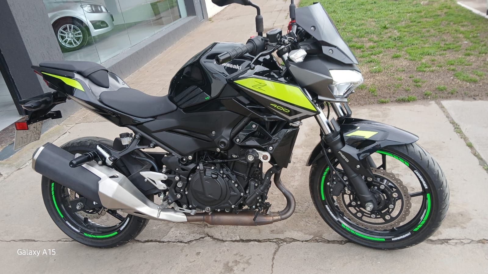 Motocicleta Kawasaki negra y verde estacionada al aire libre.