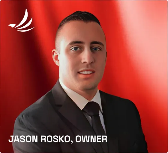 Jason Rosko, owner, wearing a suit and tie against a red background with a white logo in the top left.