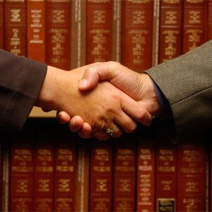 I Need A Lawyer — Handshake With Law Books in Background in North Attleborough, MA