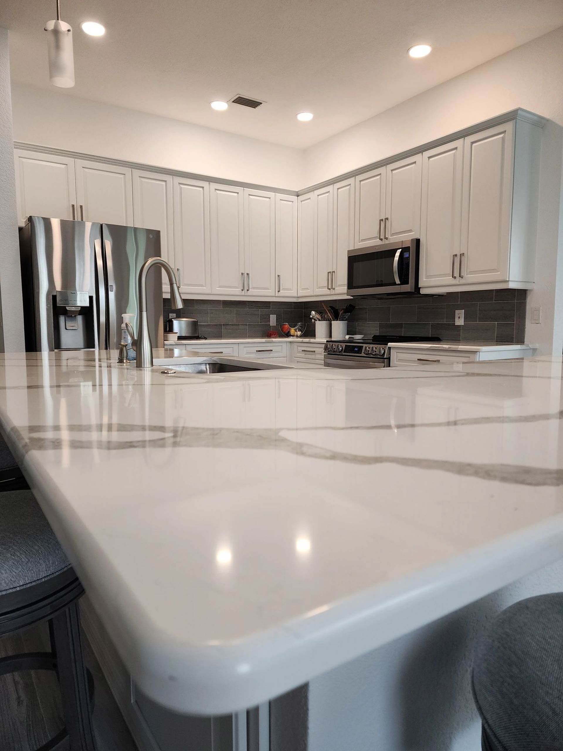 A kitchen with white cabinets and a white counter top