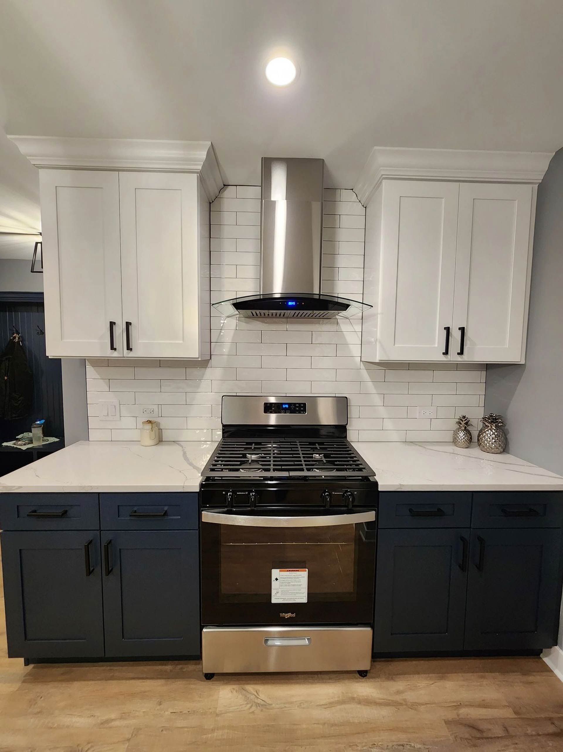 A kitchen with blue cabinets, a stove, and a hood