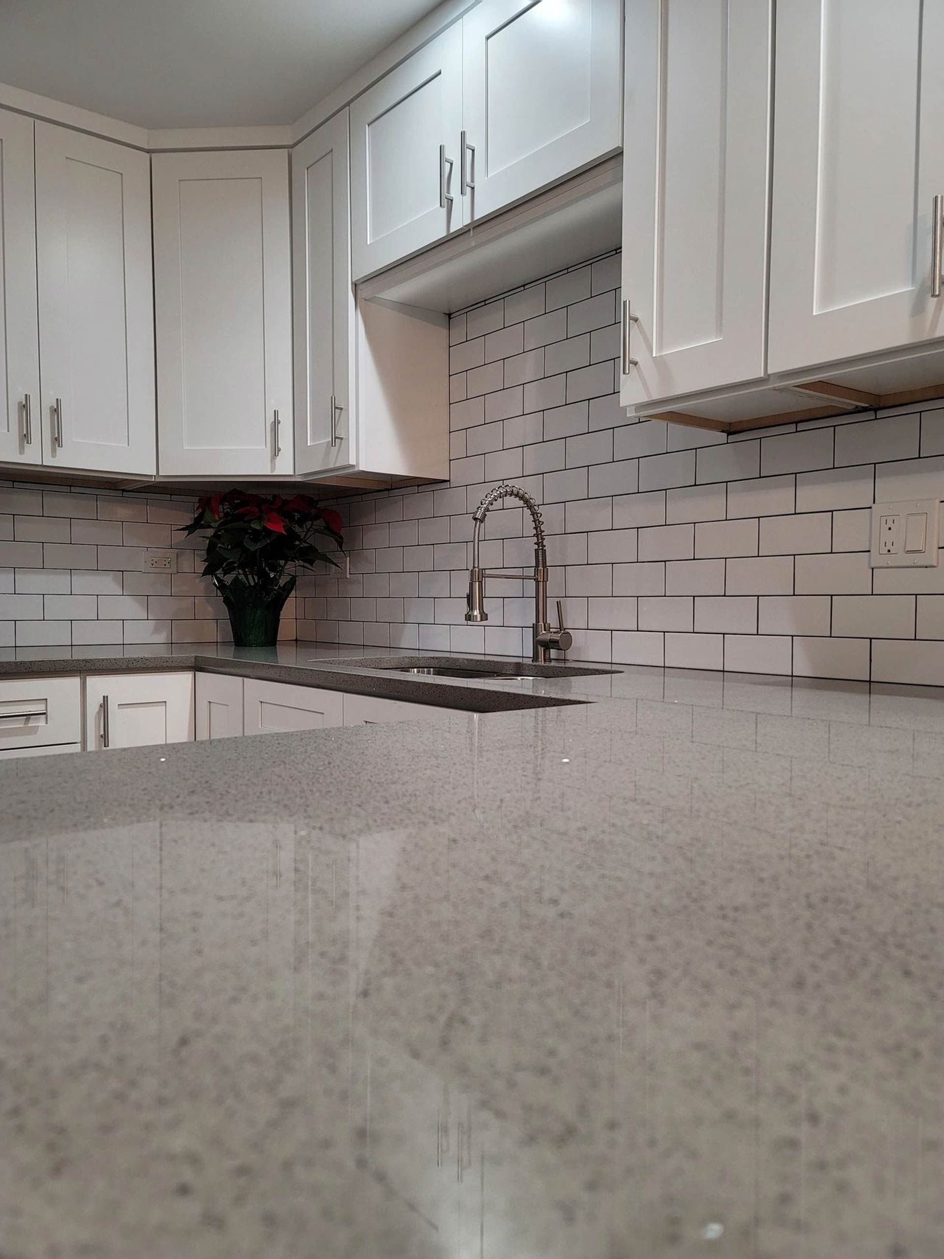 A kitchen with white cabinets and granite counter tops