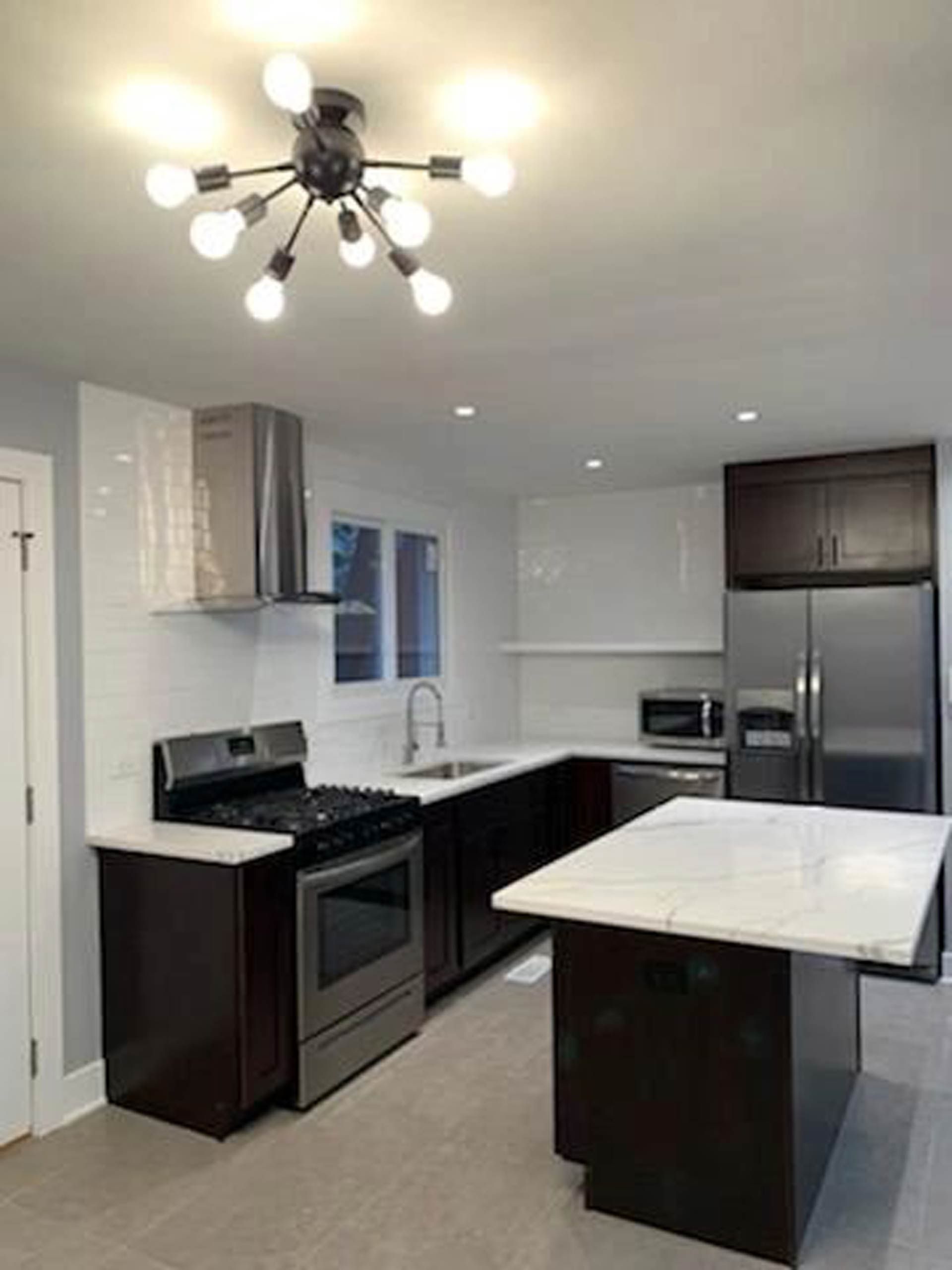 A kitchen with stainless steel appliances and a large island