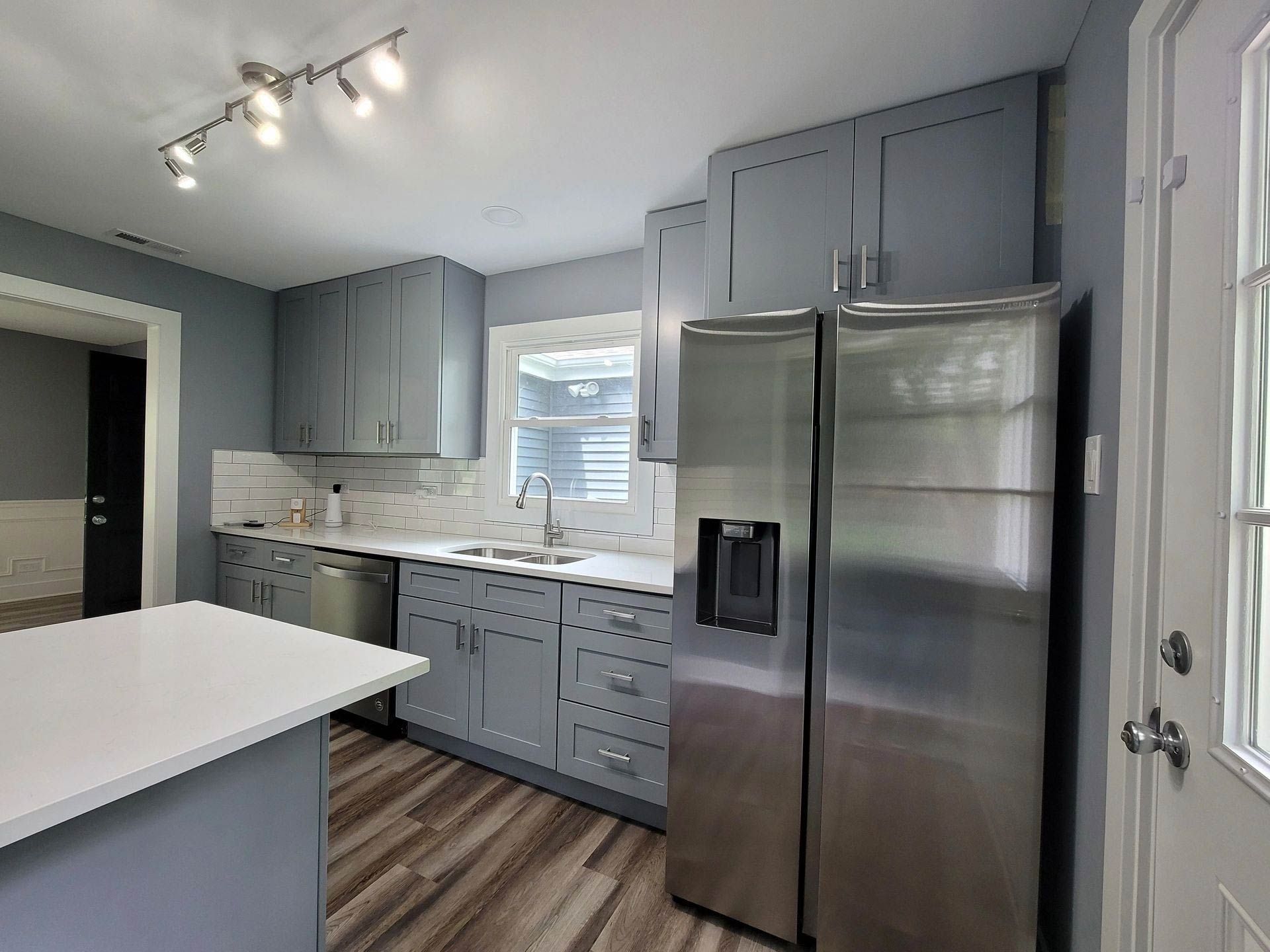 A kitchen with stainless steel appliances and gray cabinets