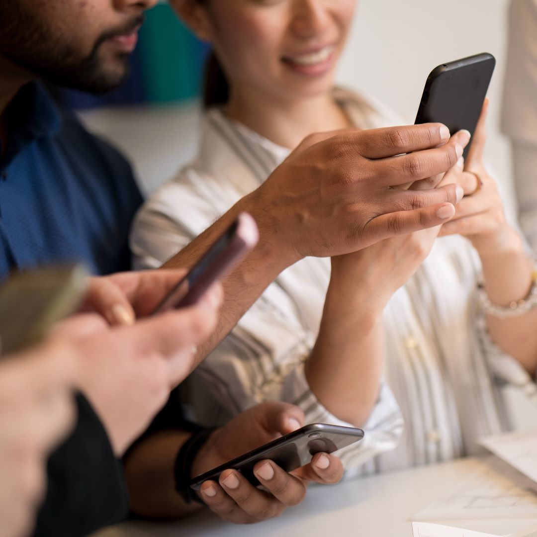 Person using smartphone to manage paid social media ad campaign for brand visibility