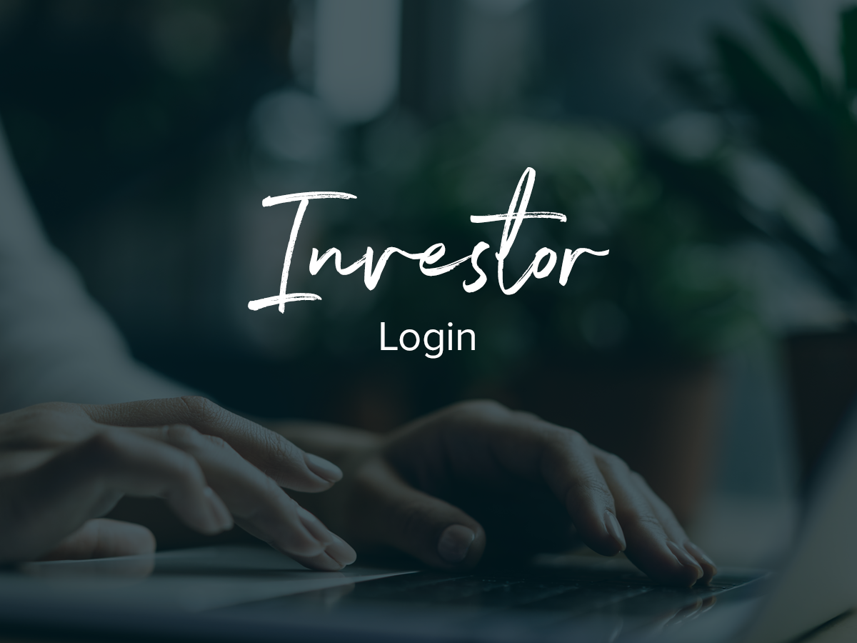 A person is typing on a laptop with the words investor login below them