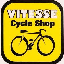 A yellow sign with a bicycle on it that says vitesse cycle shop.