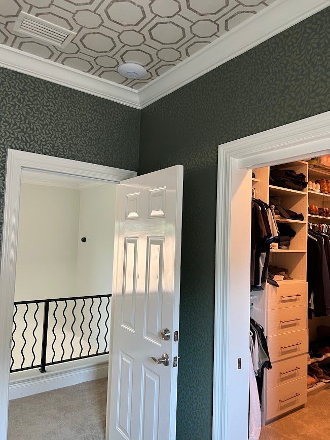 Interior view: doorway to a hallway, closet, and loft. Green textured walls, white trim and doors.