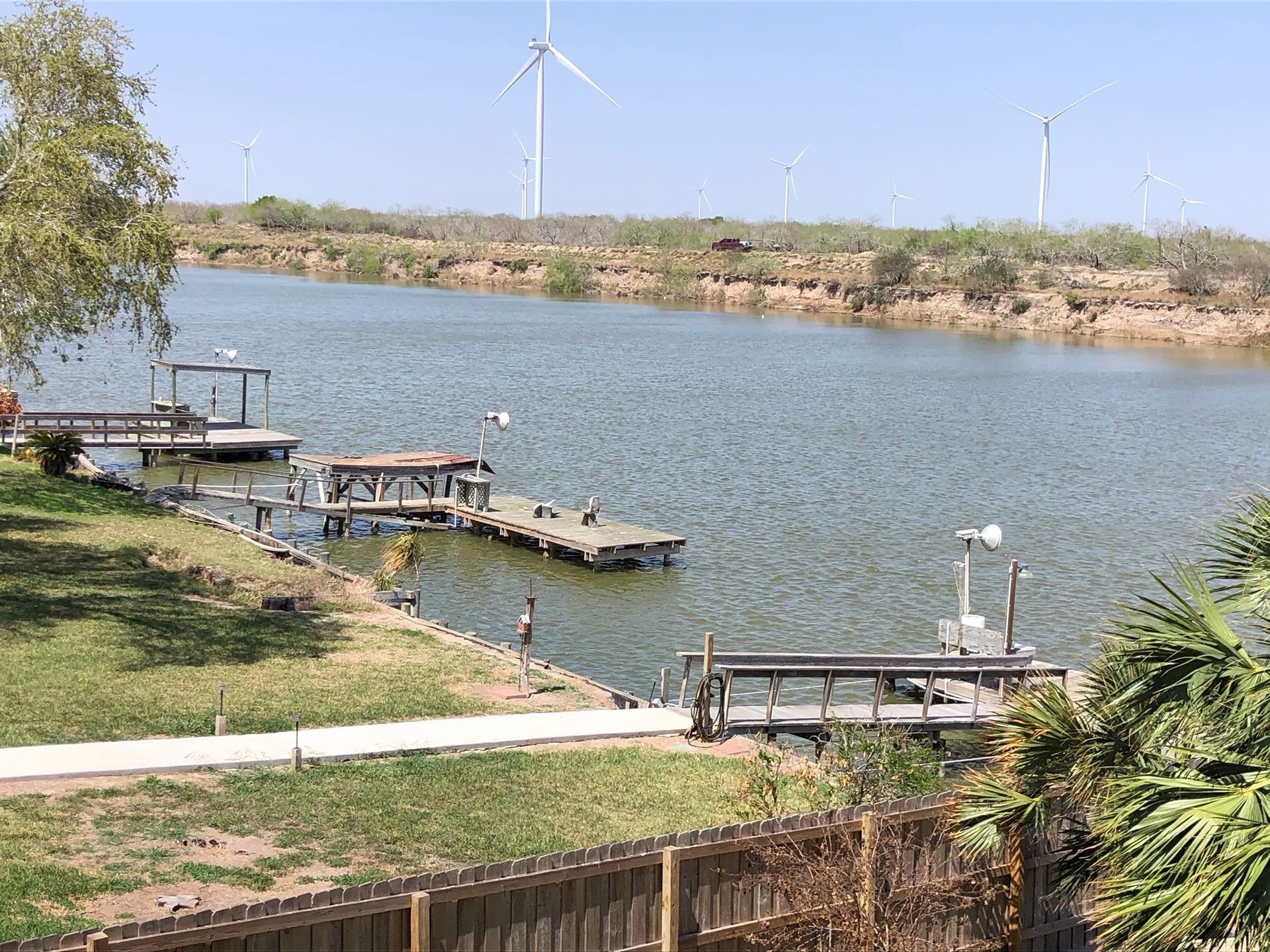 A large body of water with a dock and a windmill in the background.