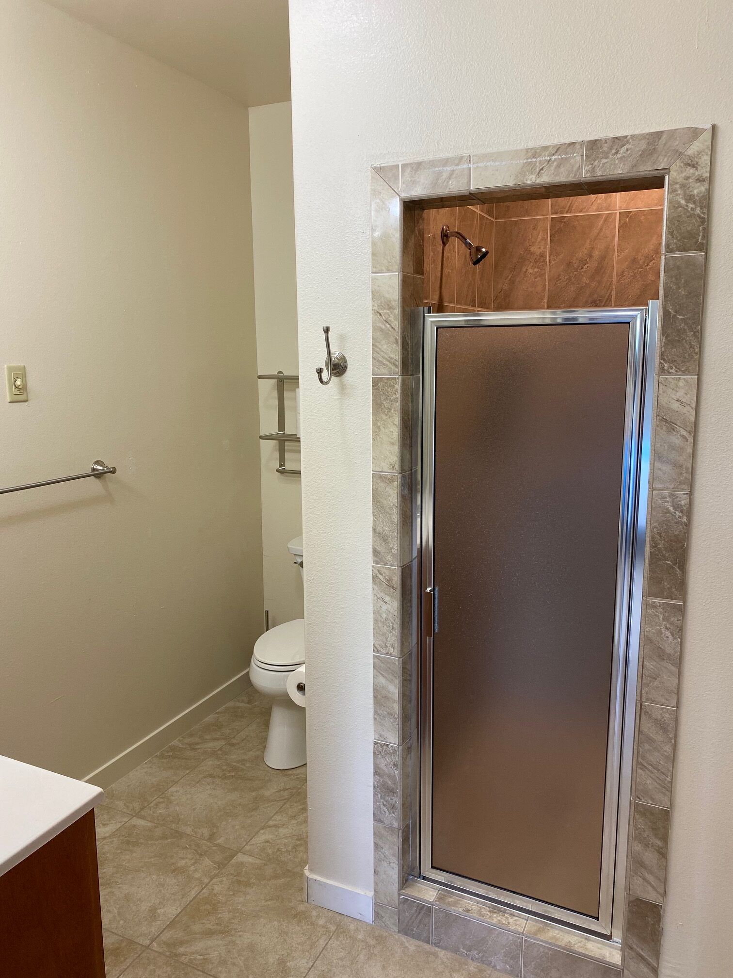 A bathroom with a toilet and a shower stall.