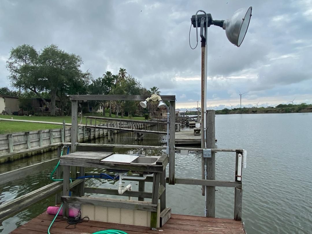 A dock with a satellite dish on top of it next to a body of water.