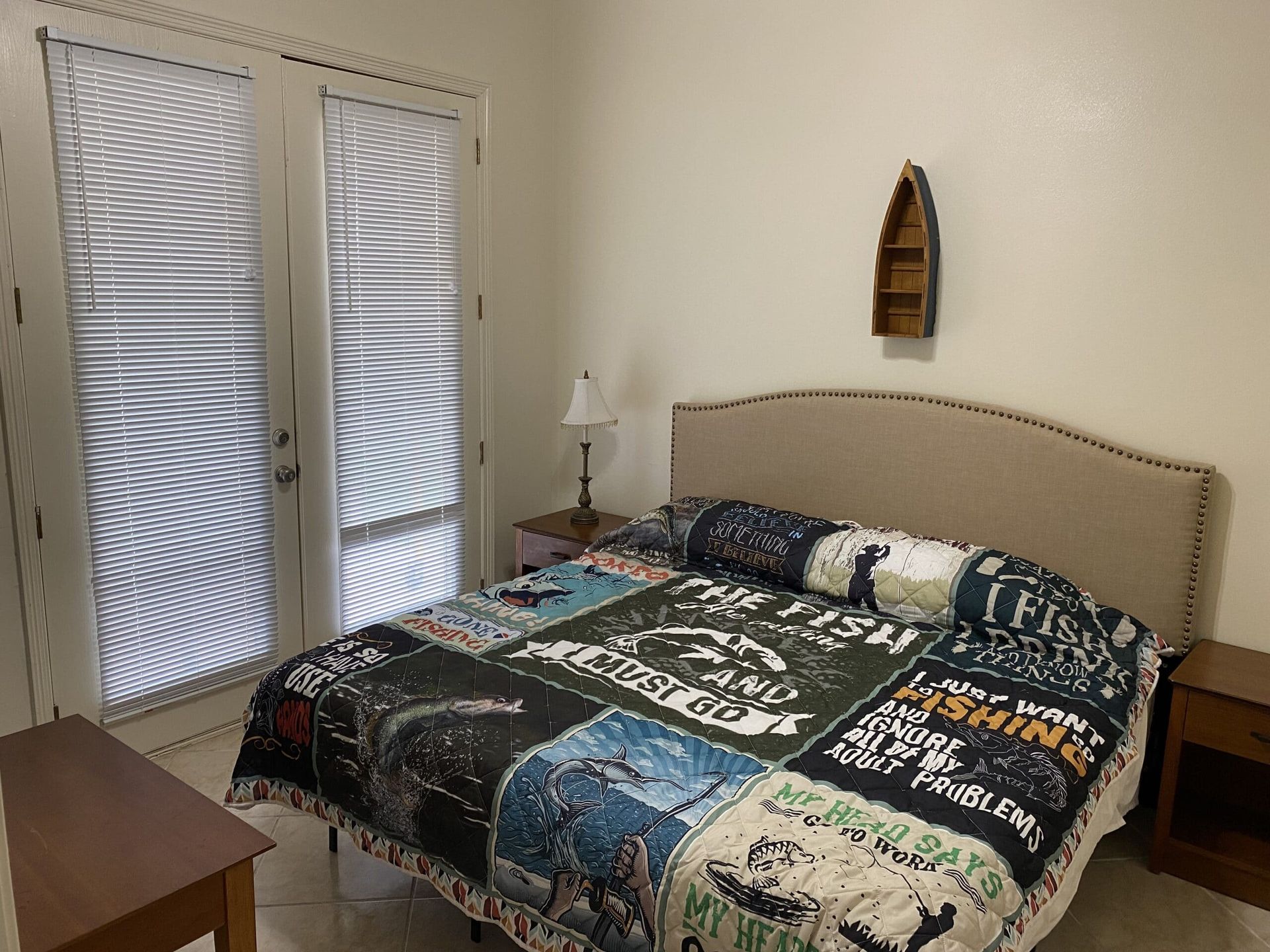 A bedroom with a bed and a boat on the wall