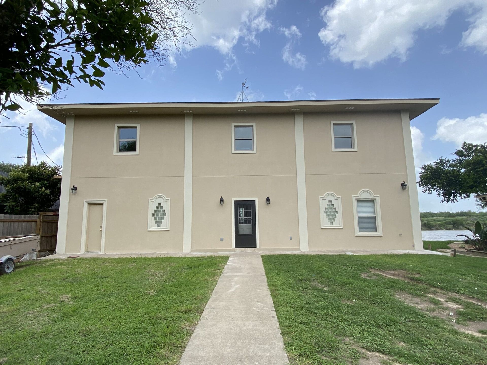 A large house with a lot of windows and a walkway leading to it.
