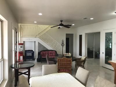 A living room with a table and chairs and a ceiling fan.