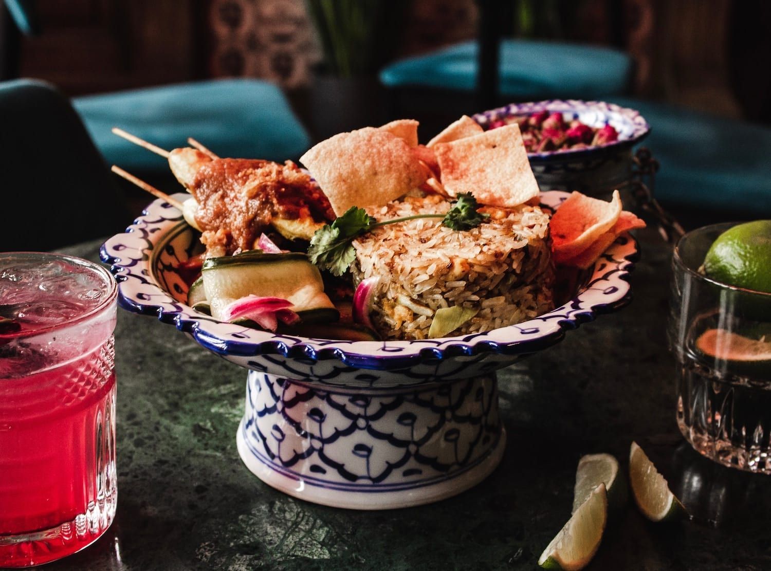 A bowl of food is sitting on a table next to a drink.