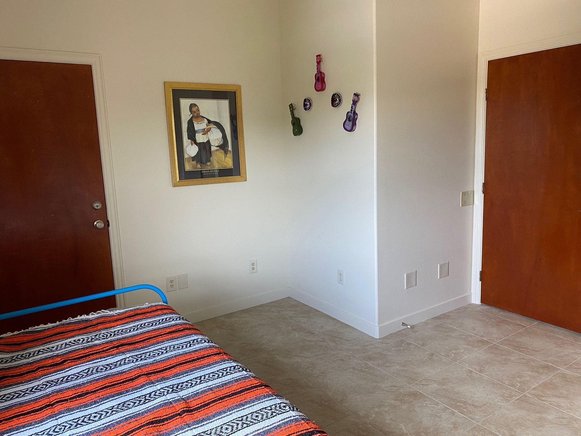 A bedroom with a bed and a picture on the wall.