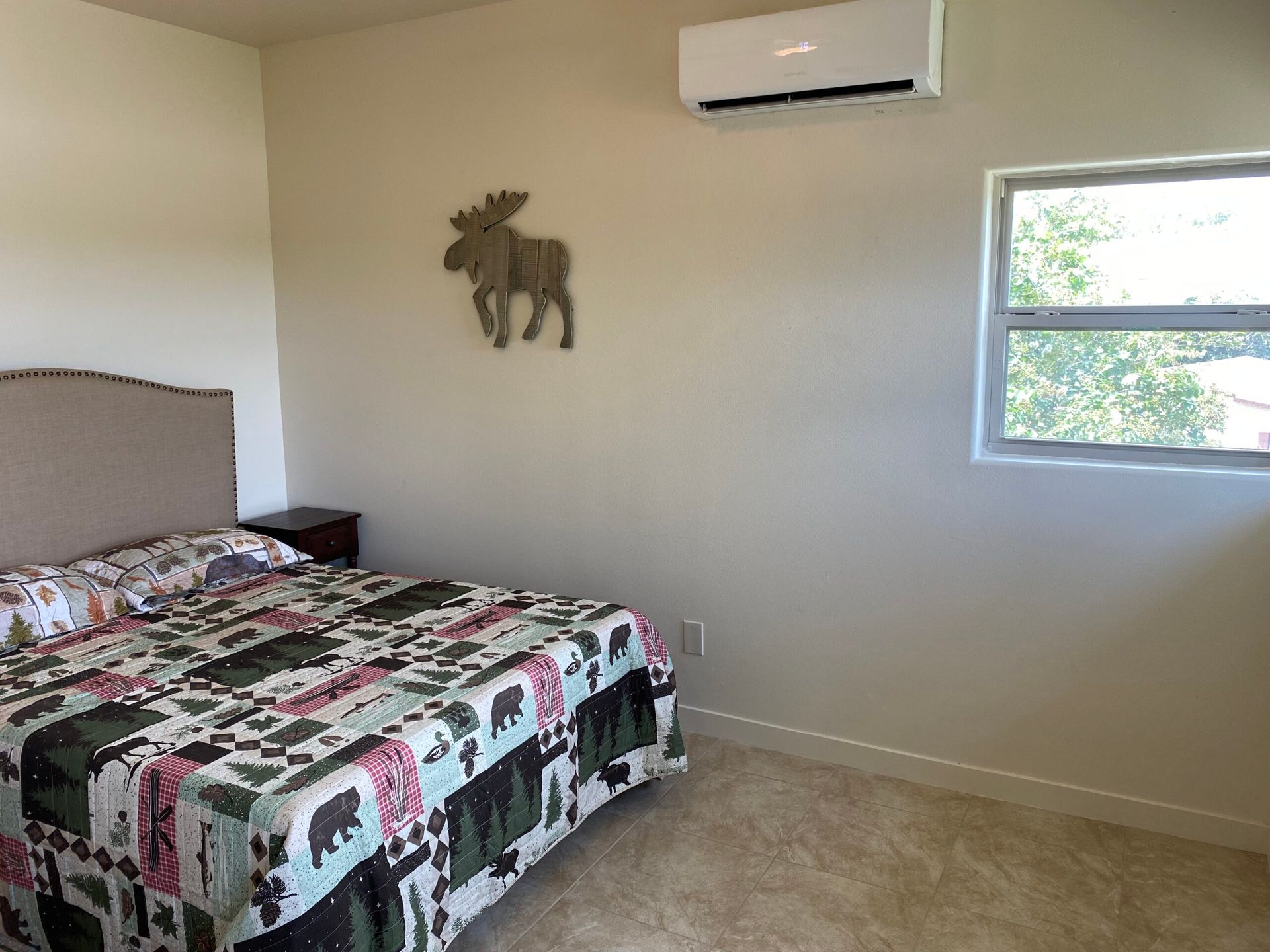 There is a moose on the wall above the bed in the bedroom.