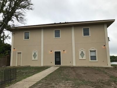 A large house with a lot of windows and a walkway leading to it.