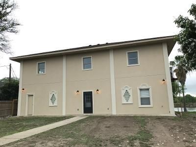 A large house with a lot of windows and a walkway leading to it.