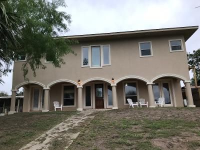 A large house with a lot of windows and chairs in front of it.