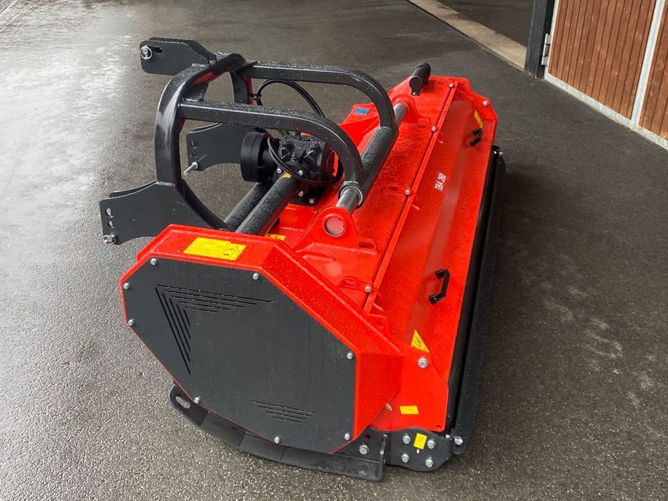 Eine rot-schwarze Maschine steht am Straßenrand.