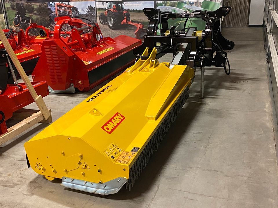 In einer Garage steht ein gelb-roter Traktor.