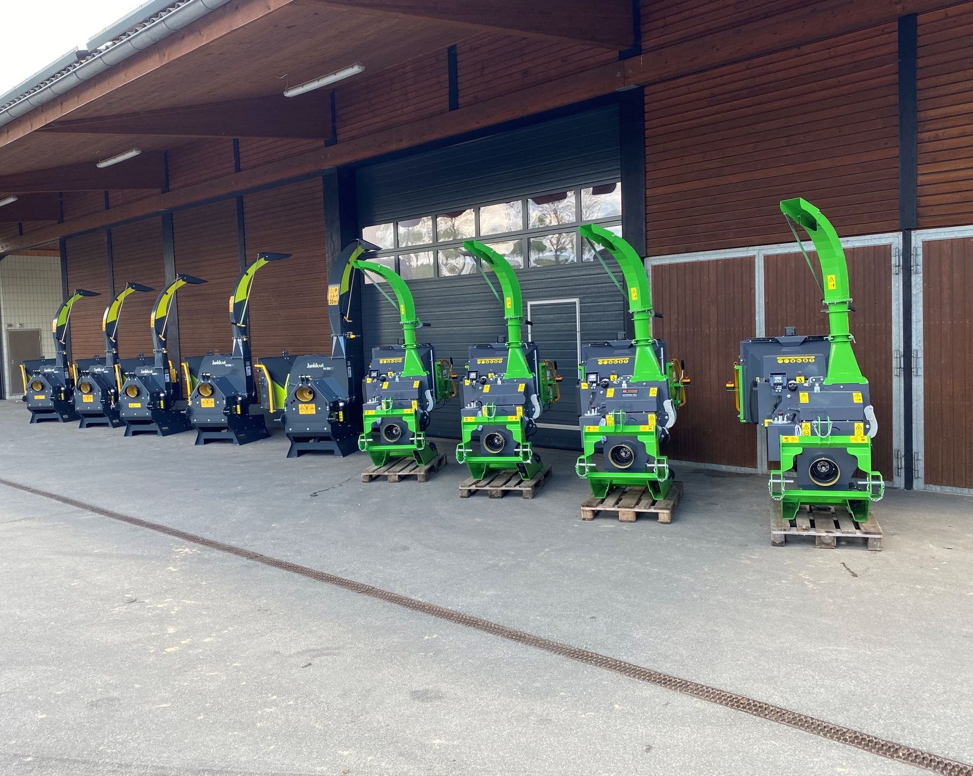 Eine Reihe grüner Maschinen steht vor einem Gebäude