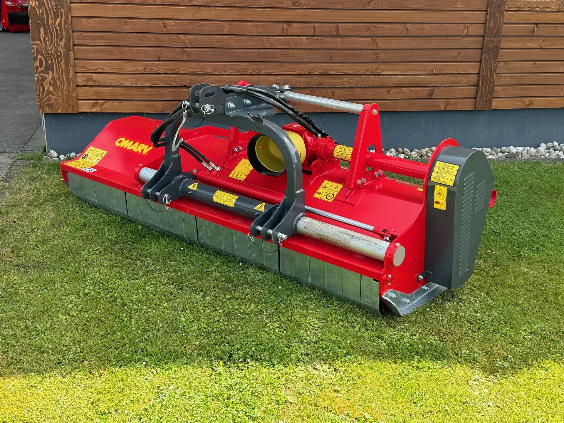Eine rot-silberne Maschine steht auf einem üppigen grünen Feld.
