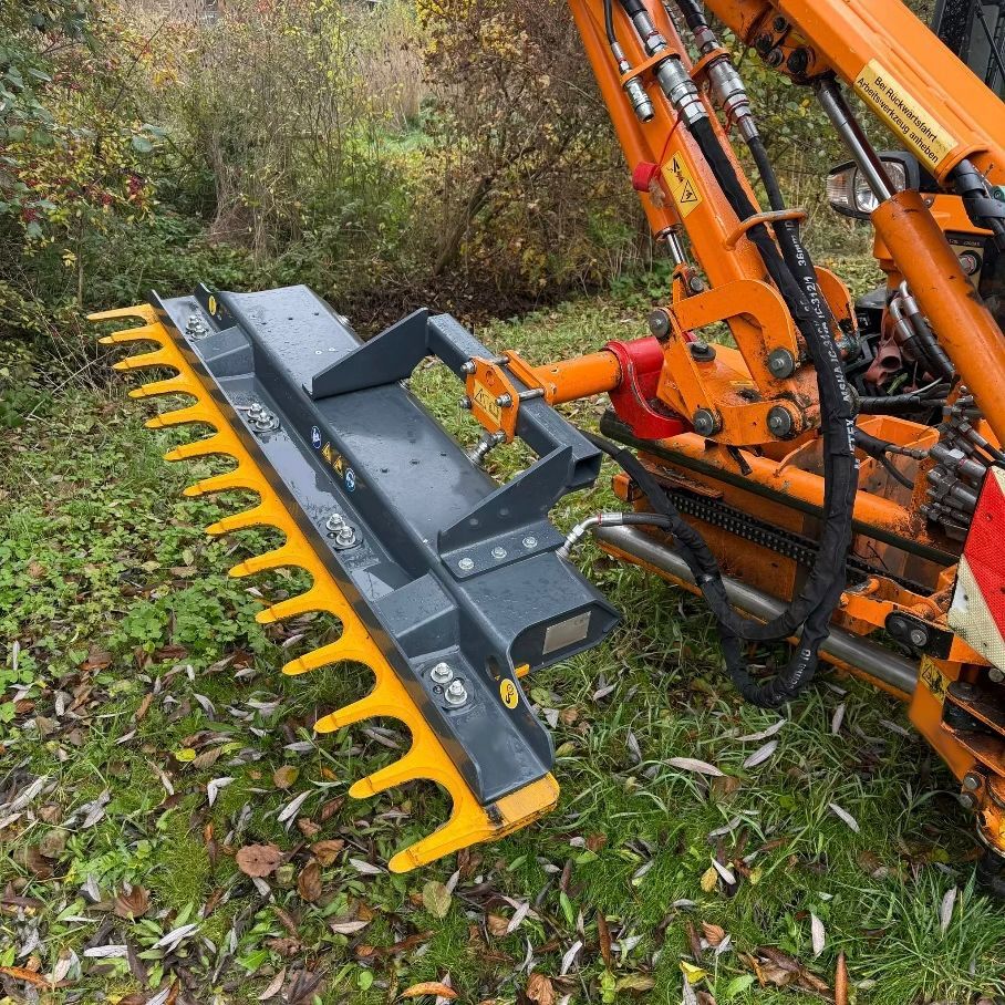 Auf dem Boden steht ein rot-grauer Rasenmäher.