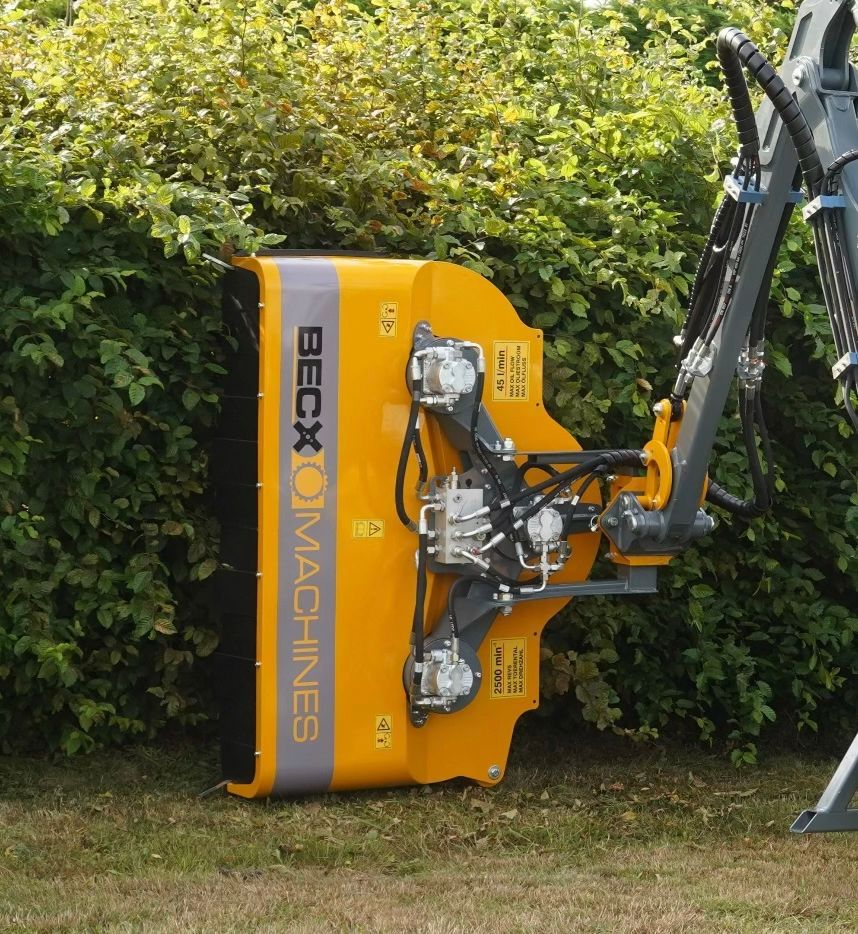 Yellow Beck O Maschinen Heckenschere schneidet eine grüne Hecke.