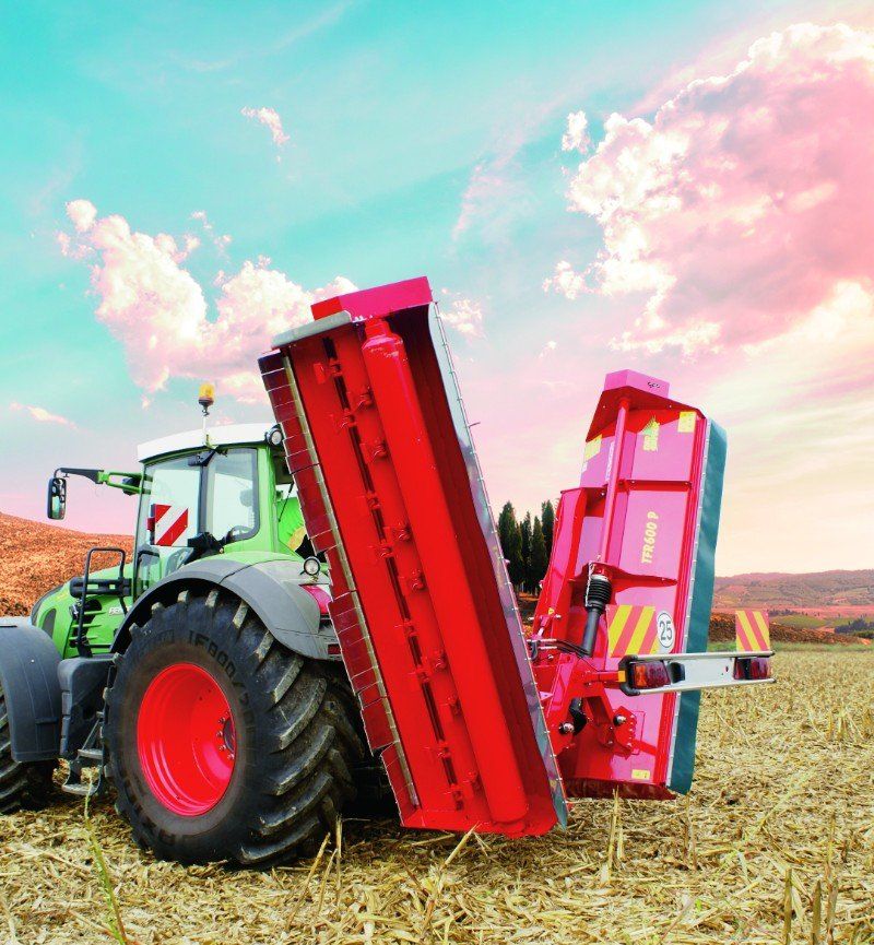 Ein roter und grüner Traktor steht auf einem Feld