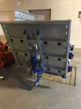 In einer Lagerhalle liegt ein großes Metallobjekt auf dem Boden.