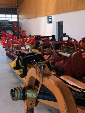 Eine Reihe von Traktoren steht in einer Lagerhalle