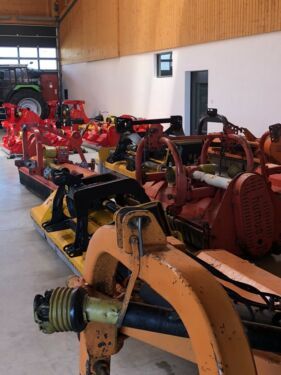 Eine Reihe von Traktoren steht in einer Lagerhalle