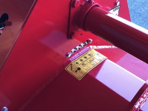 Eine rote Maschine mit einem gelben Warnaufkleber darauf