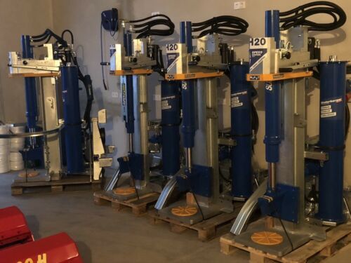 In einem Raum stehen mehrere blaue und silberne Maschinen aufgereiht.