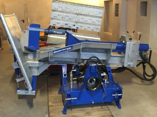 Eine blau-silberne Maschine steht auf einem Holzboden.