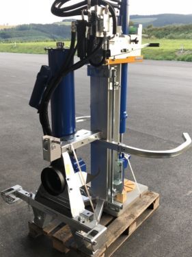 Eine blau-silberne Maschine steht auf einer Holzpalette