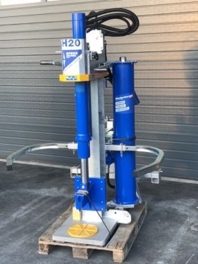 Eine blau-weiße Maschine steht auf einer Holzpalette.