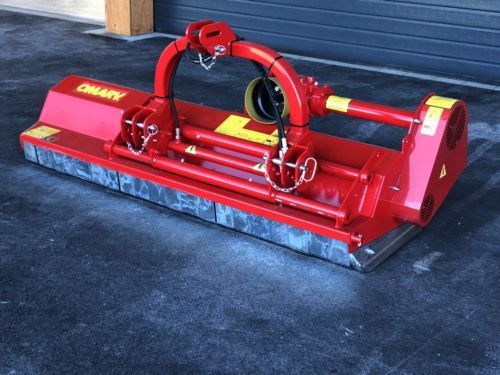 Eine rote Maschine steht auf dem Boden vor einem Garagentor.