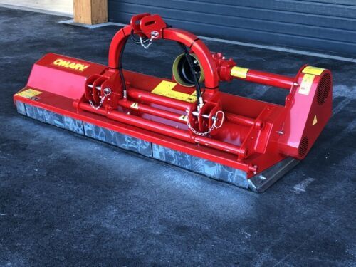 Eine rote Maschine steht auf dem Boden vor einem Garagentor.