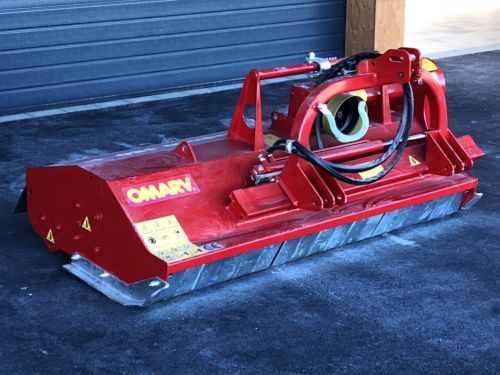 Eine rote Maschine steht auf dem Boden vor einem Garagentor.