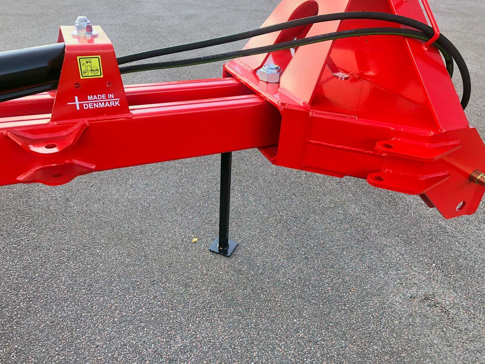 Ein roter Traktor steht auf einer Schotterstraße