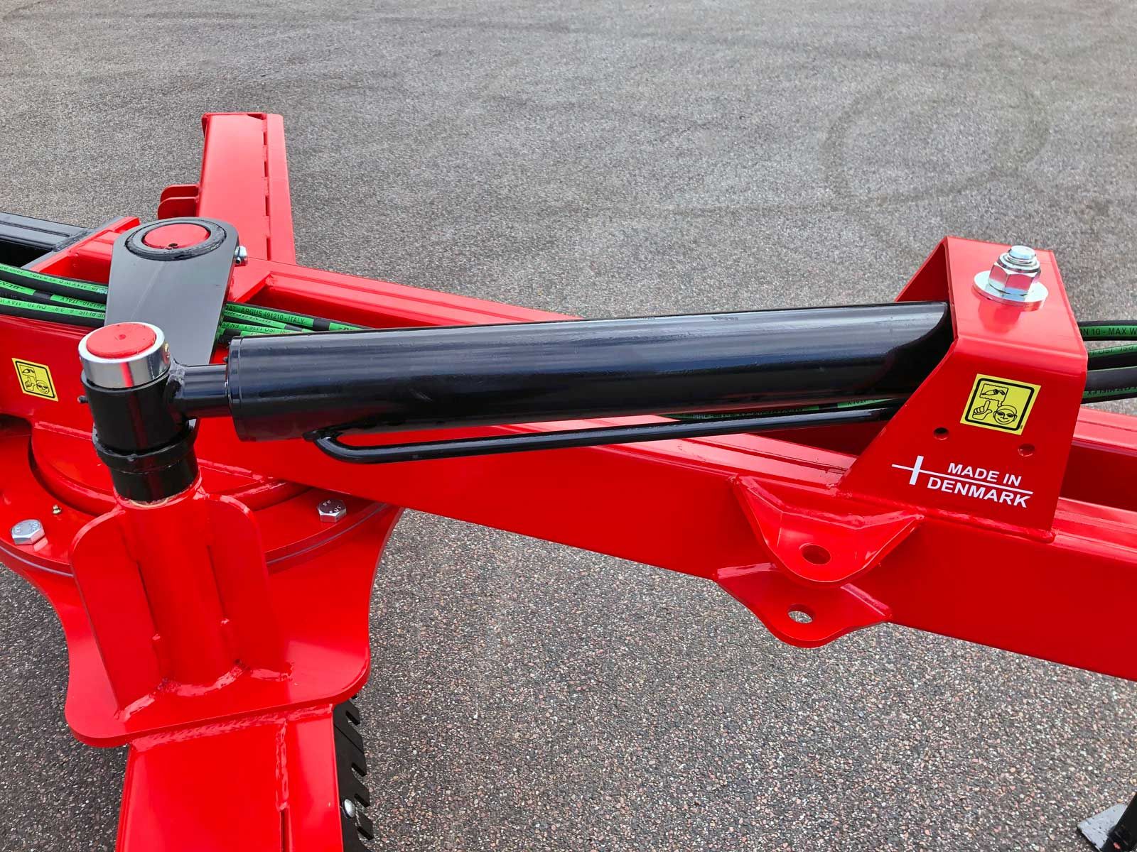 Ein roter Traktor mit einem daran befestigten schwarzen Schlauch