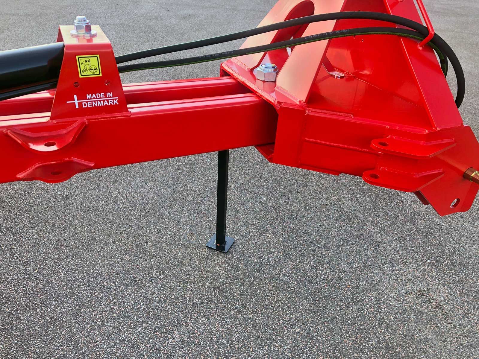 Ein roter Traktor steht auf einer Schotterstraße