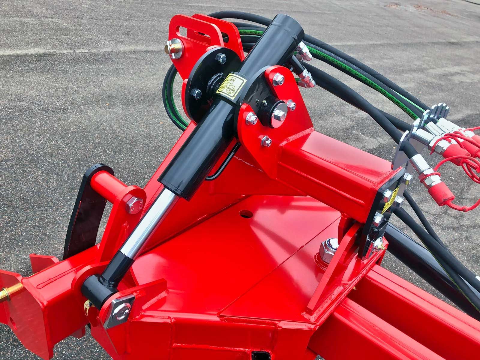 Ein roter Traktor mit daran befestigten Hydraulikzylindern