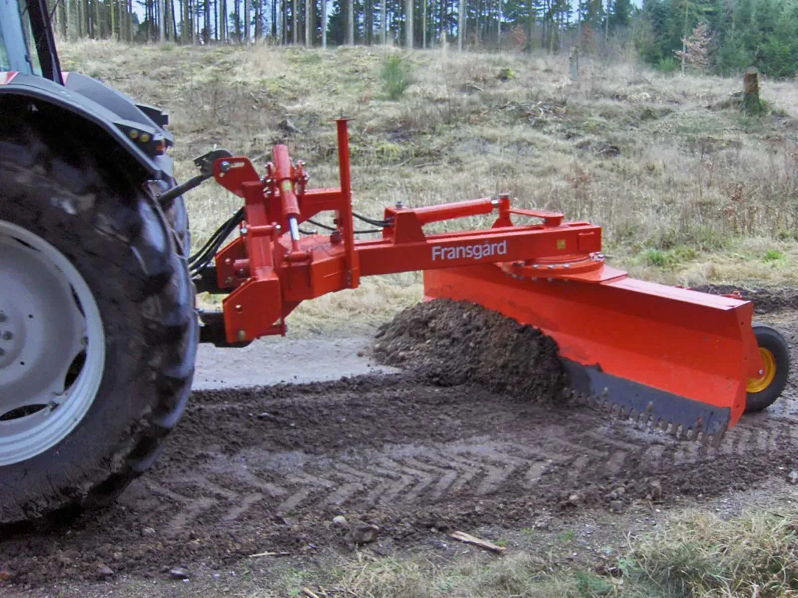 Ein Traktor mit einem daran befestigten roten Pflug