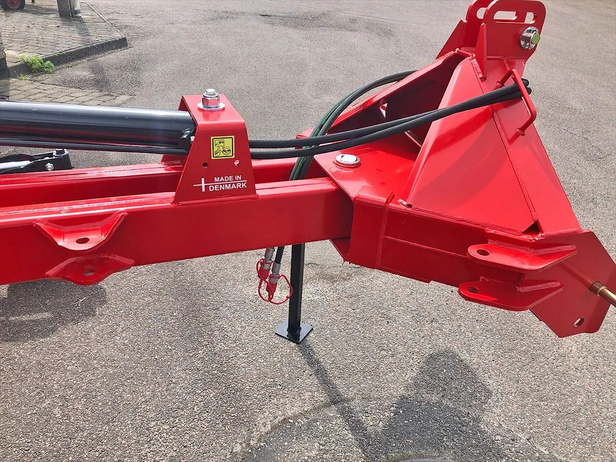 Ein roter Traktor steht am Straßenrand.